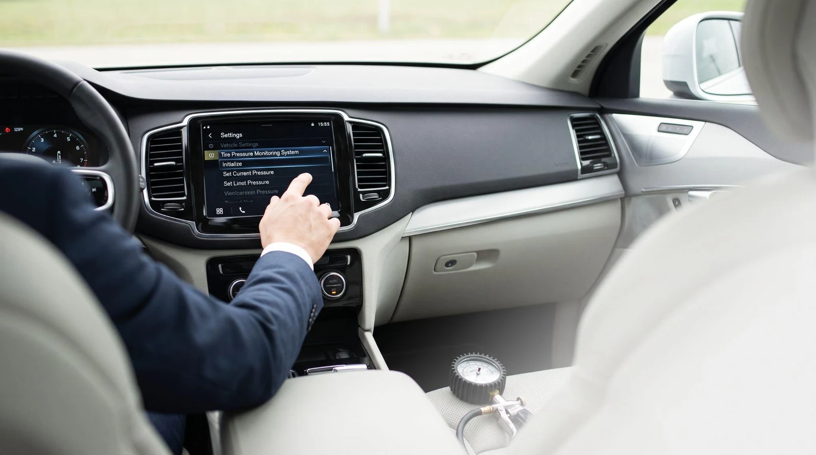 Person resetting tire pressure sensor on dashboard screen.